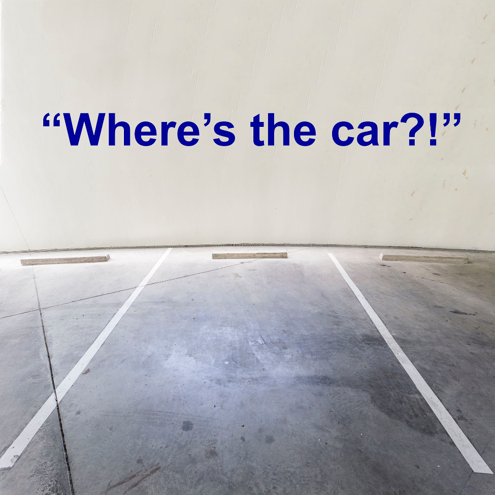 Empty parking garage with text 'Where's the car?!' on a white wall.